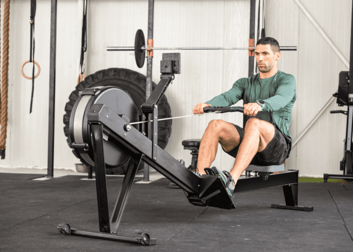 CrossFitter using a rowing machine in a gym