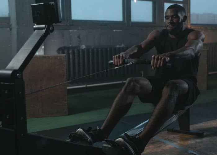 athlete working out on rowing machine in the gym