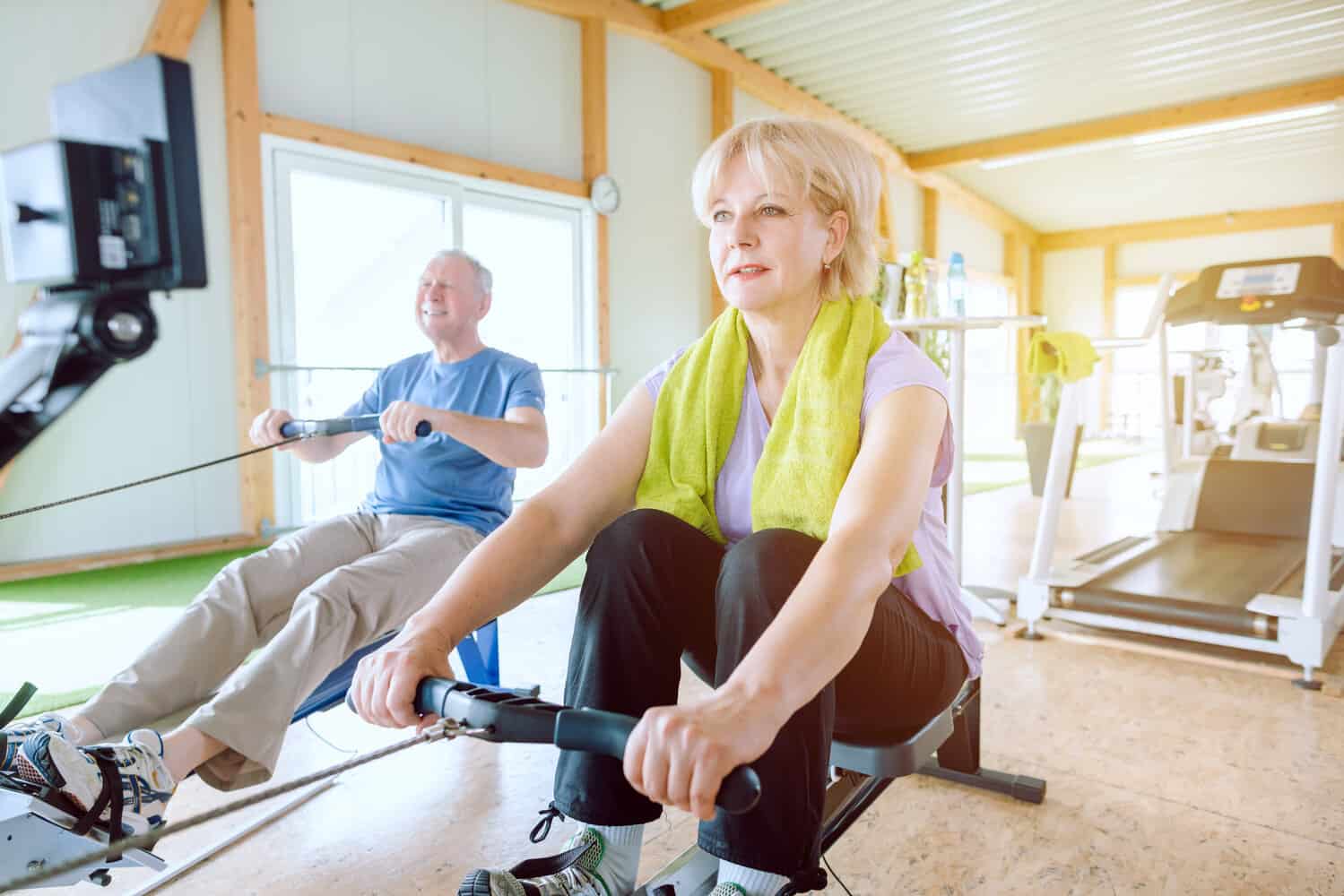 Senior couple in the gym on a rowing machine